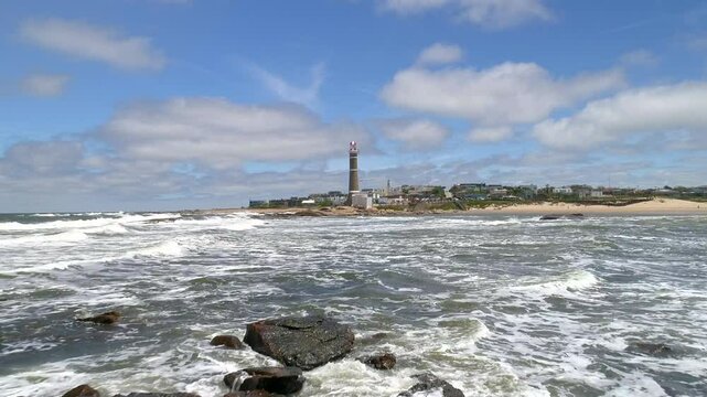 Aerial view of the beautiful coastline with a lighthouse and serene ocean waves, Jose Ignacio, Uruguay.