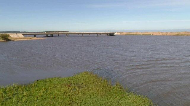 Aerial view of laguna garzon bridge over serene waters and expansive landscape with cars, Maldonado, Uruguay.