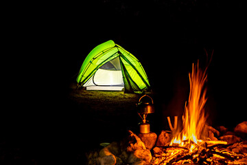 Overnight stay in a tent in the mountains at night, near a fire.