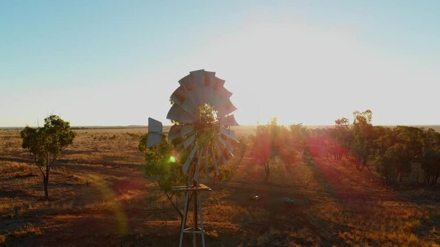 Aerial view of an old windmill at sunset in the dry outback landscape, Emerald, Queensland, Australia.