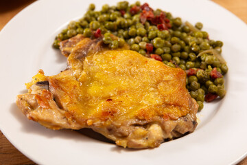Delicious crispy chicken with peas as a side dish on a plate