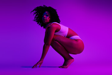 Full size profile portrait of gorgeous model girl posing underwear vibrant purple neon studio background © deagreez