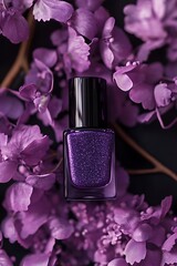 Minimalist stock photo of a purple nail polish bottle surrounded by lilac flowers on a dark violet background