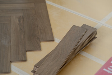 Laminate floor installation in a modern apartment, showing tools, planks