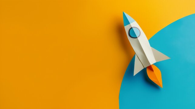 A small paper rocket ship rests on a vibrant yellow and blue background, symbolizing creativity, dreams, and the pursuit of adventure.
