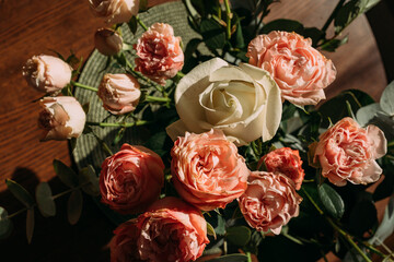 A bouquet of pink and white roses for the wedding anniversary for your beloved wife. A bouquet of roses and eucalyptus twigs. A bouquet of flowers on the table