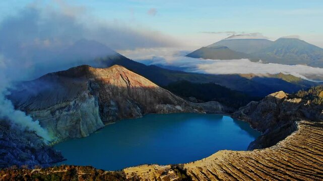 Aerial view of the beautiful Ijen volcano with a stunning crater lake surrounded by mist and smoke at sunrise, Kawah Ijen, Java, Indonesia.