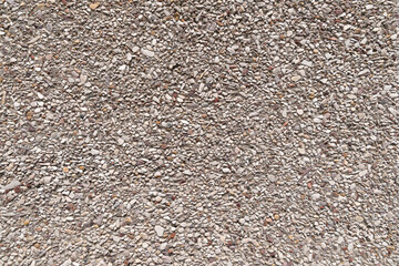 textured surface made of small, irregularly shaped stones embedded in a concrete. Backgrounds