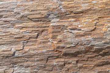A close-up texture of a layered, weathered rock formation with varying shades of gray. Backgrounds