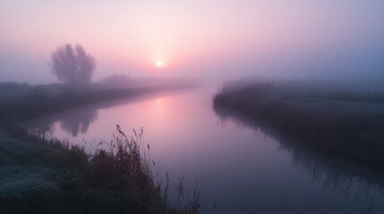 Fototapeta premium A serene sunrise over a foggy river, creating a tranquil and reflective atmosphere.