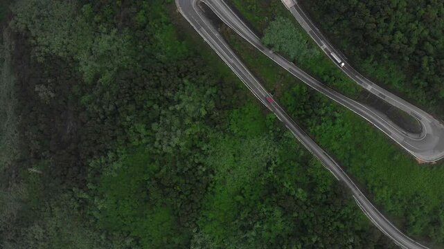 Aerial view of winding road through the mountain with traffic including motorcycles and trucks, Hai Van Pass, Da Nang, Vietnam.