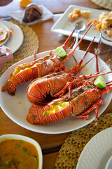 Cooked butter Lobster on the wooden table with spicy seafood sauce and lemon, Mancora Piura Peru on a sunny day.