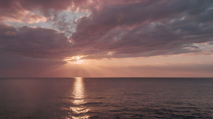Fototapeta premium A serene sunset over the calm ocean with dramatic clouds reflecting various colors on the water's surface at twilight