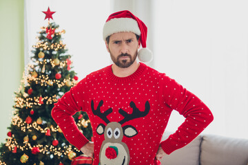 Portrait of nice young man put hands waist sullen face ugly sweater new year atmosphere flat indoors