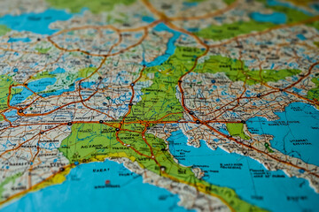 Naklejka premium Paper map for country trips in light blue, beige, light green colors. Paper map on table, focus on one city, very detailed map, arrows, marks, marked points, soft 3d pins