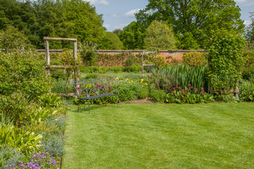attractive metal bench in a beautiful English country garden