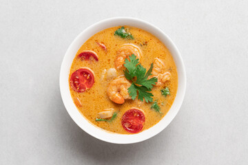 Tom yum soup with shrimps in white bowl on light background with copy space. Popular traditional asian cuisine