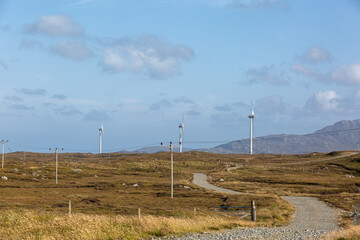 Wind turbines in South Uist, Image shows wind turbines in the remote Scottish island's landscape on a summers day with a mountain background view 