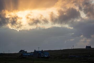 Obraz premium Sunset view over South Uist, Image shows a cloudy sunset with the golden hour sun rays shining through 