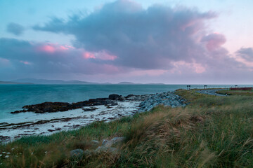 Evening view from a beach in south Uist, Image shows long exposure photo showing a small beach after sunset showing a beautiful blue and purple sky