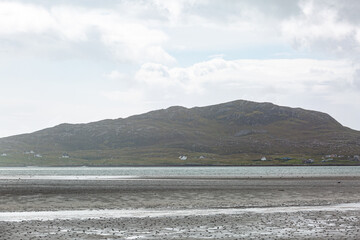 View of Eriskay from South Uist across the water, Image shows the scenic mountain of Eriskay as heavy rainfall pours down  
