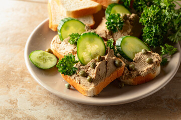 Open pate sandwiches with fresh cucumber, capers, and parsley.