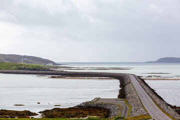 View of Eriskay causeway from a hill , Image shows the causeway connecting Eriskay to south Uist from a hill on the south Uist side on a cloudy summers day