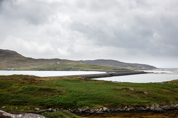 View of Eriskay causeway from a hill , Image shows the causeway connecting Eriskay to south Uist from a hill on the south Uist side on a cloudy summers day