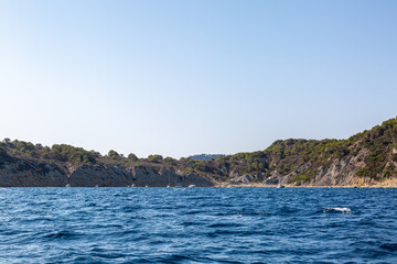Naklejka premium Coastal landscape image of the cliffs along the Spanish coastline from a boat, Image shows a beautiful scenic photo of the cliffs with blue skies and blue sea 