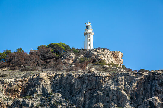 View of Faro Cabo De La Nao a historical lighthouse along the Spanish coastline of Xabia and Javea, Image shows a view of the historical landmark built in 1923 on a 200m cliff from the sea