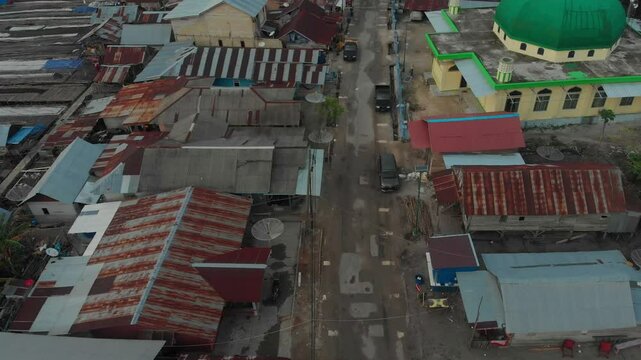 Aerial view of a beautiful fishing village at sunset with rooftops and roads, Tanjung Binga, Indonesia.
