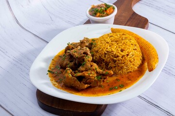 A mouthwatering dish of Seco de chivo chancho featuring a rich and savory sauce, served with tender chunks of goat, pork, and beef. Accompanied by a generous portion of moros de lenteja (lentil rice)