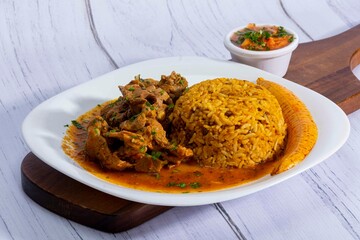 A mouthwatering dish of Seco de chivo chancho featuring a rich and savory sauce, served with tender chunks of goat, pork, and beef. Accompanied by a generous portion of moros de lenteja (lentil rice)