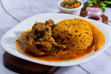 A mouthwatering dish of Seco de chivo chancho featuring a rich and savory sauce, served with tender chunks of goat, pork, and beef. Accompanied by a generous portion of moros de lenteja (lentil rice)