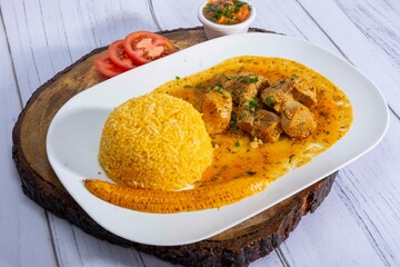 A mouthwatering dish of Seco de chivo chancho featuring a rich and savory sauce, served with tender chunks of goat, pork, and beef. Accompanied by a generous portion of moros de lenteja (lentil rice)