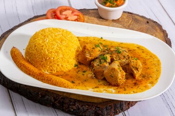 A mouthwatering dish of Seco de chivo chancho featuring a rich and savory sauce, served with tender chunks of goat, pork, and beef. Accompanied by a generous portion of moros de lenteja (lentil rice)