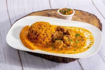 A mouthwatering dish of Seco de chivo chancho featuring a rich and savory sauce, served with tender chunks of goat, pork, and beef. Accompanied by a generous portion of moros de lenteja (lentil rice)
