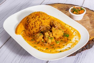A mouthwatering dish of Seco de chivo chancho featuring a rich and savory sauce, served with tender chunks of goat, pork, and beef. Accompanied by a generous portion of moros de lenteja (lentil rice)