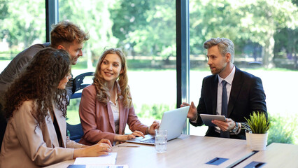 Group of business partners discussing ideas and planning work in office.