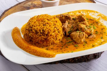A mouthwatering dish of Seco de chivo chancho featuring a rich and savory sauce, served with tender chunks of goat, pork, and beef. Accompanied by a generous portion of moros de lenteja (lentil rice)
