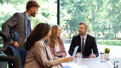 Group of business partners discussing ideas and planning work in office.