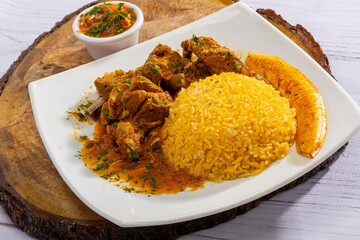 A mouthwatering dish of Seco de chivo chancho featuring a rich and savory sauce, served with tender chunks of goat, pork, and beef. Accompanied by a generous portion of moros de lenteja (lentil rice)