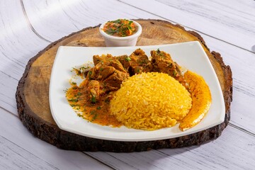 A mouthwatering dish of Seco de chivo chancho featuring a rich and savory sauce, served with tender chunks of goat, pork, and beef. Accompanied by a generous portion of moros de lenteja (lentil rice)