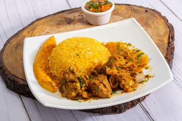 A mouthwatering dish of Seco de chivo chancho featuring a rich and savory sauce, served with tender chunks of goat, pork, and beef. Accompanied by a generous portion of moros de lenteja (lentil rice)