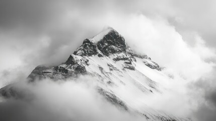 A majestic snow-capped mountain peak shrouded in clouds, evoking a sense of mystery.