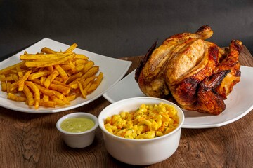 Deliciously charred and smoky Pollo a la Brasa (grilled chicken) served whole and in pieces, accompanied by crispy fries, fresh salad, and a flavorful dipping sauce. A classic Latin American dish, coo