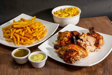 Deliciously charred and smoky Pollo a la Brasa (grilled chicken) served whole and in pieces, accompanied by crispy fries, fresh salad, and a flavorful dipping sauce. A classic Latin American dish, coo