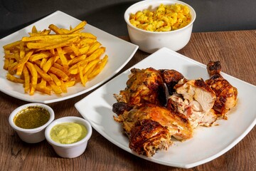 Deliciously charred and smoky Pollo a la Brasa (grilled chicken) served whole and in pieces, accompanied by crispy fries, fresh salad, and a flavorful dipping sauce. A classic Latin American dish, coo