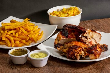 Deliciously charred and smoky Pollo a la Brasa (grilled chicken) served whole and in pieces, accompanied by crispy fries, fresh salad, and a flavorful dipping sauce. A classic Latin American dish, coo