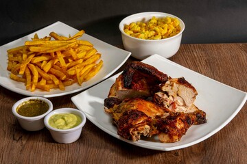Deliciously charred and smoky Pollo a la Brasa (grilled chicken) served whole and in pieces,...